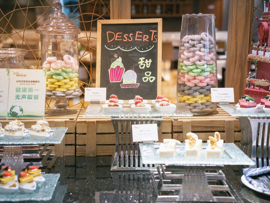 A dessert display with various sweets and a chalkboard sign.
