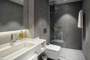 A modern bathroom with a large mirror, a white sink, a toilet, and a shower area. - Executive Residency by Best Western Amsterdam Airport (Hoofddorp)