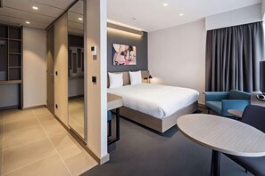 A modern hotel room with a bed, a small table, a sofa, and a large mirror. - Executive Residency by Best Western Amsterdam Airport (Hoofddorp)