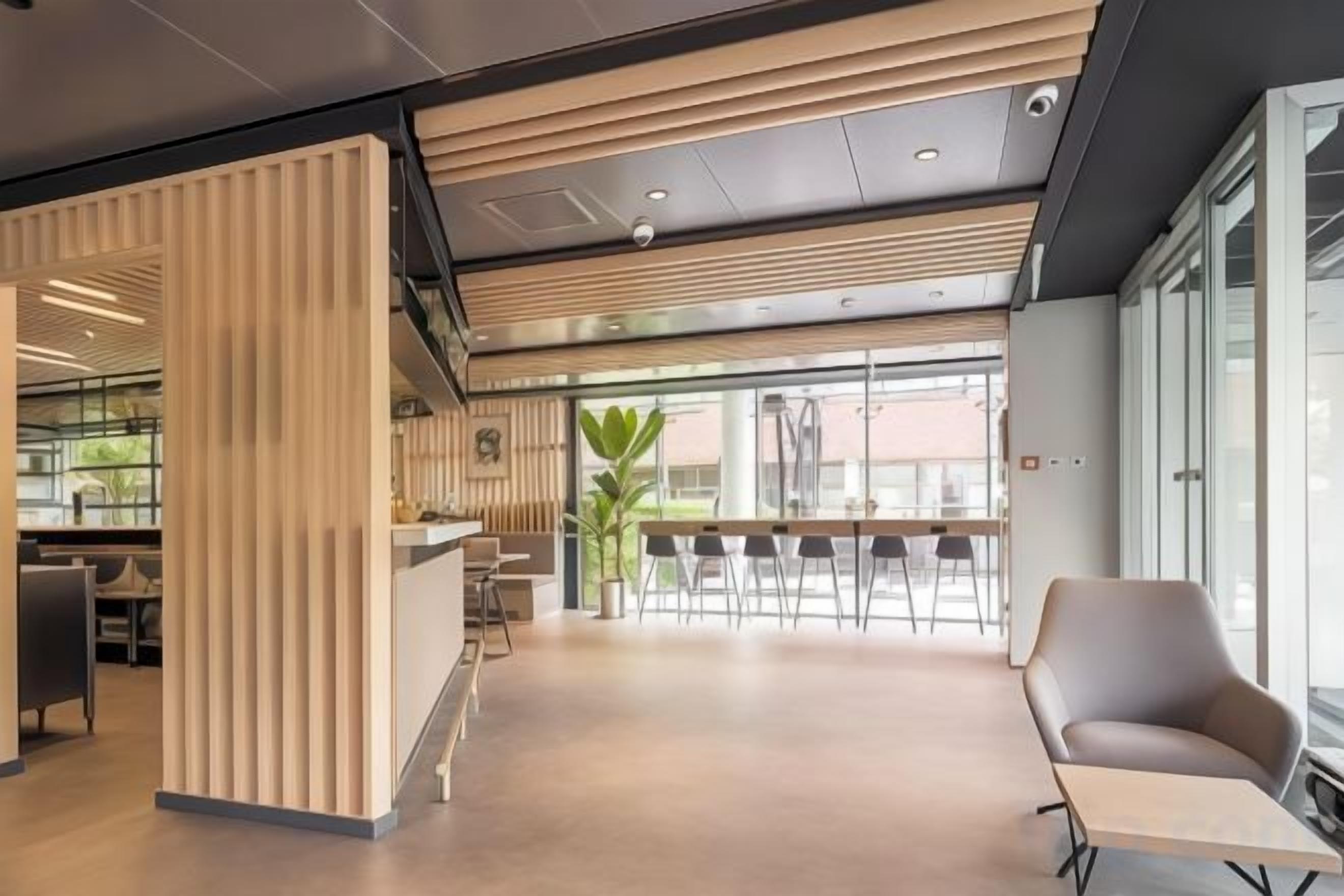 A modern interior with a reception desk, seating area, and large windows.