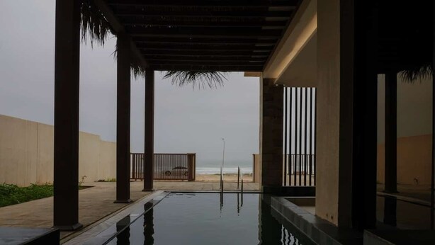 An indoor swimming pool with a view of the beach.