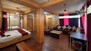 A wooden interior with a bed, sofa, and a small table. - Holiday Moods (Manali)