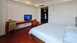 A hotel room with a bed, a desk with a computer, a wardrobe, and a door. - Chengdu Joyhub Cheer Hotel (Chengdu)
