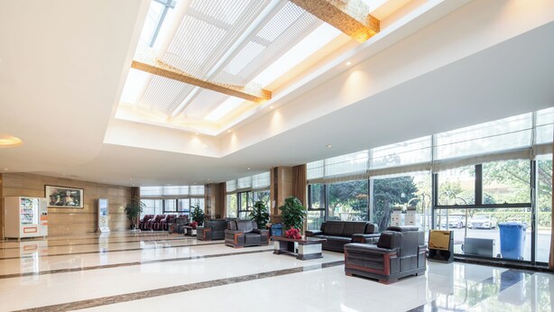 Un'ampia hall con zone salotto, ampie finestre e un moderno design del soffitto.