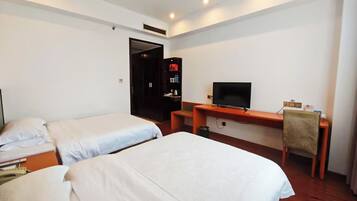 Una habitación de hotel con dos camas individuales, un escritorio con televisor y un armario.