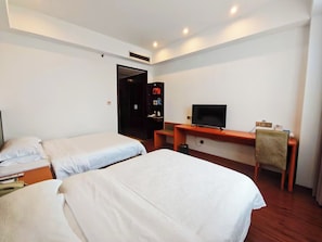 A hotel room with two single beds, a desk with a television, and a wardrobe. - Chengdu Joyhub Cheer Hotel (Chengdu)