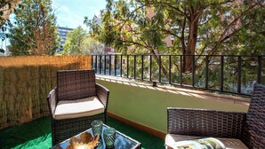 A balcony with wicker furniture, a glass table, and a magazine. - Exclusive Apartment 5BD in Seville. Carlos V (Seville)