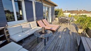 A deck with a sofa, two lounge chairs, a table, and a small fire pit. - House 300 m from the beach!  Close to Cabourg, ideal for families. (Varaville)
