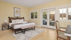 A bedroom with a bed, bedside tables, a chair, and a desk.