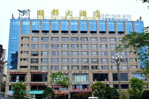 Un edificio de hotel de varios pisos con fachada moderna, ventanas grandes y un letrero llamativo en la parte superior.