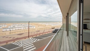 A balcony with a view of a beach and a parking area. - Apartment Knokke-heist With Sea View (Knokke-Heist)
