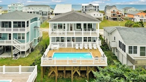 A multi-story residential building with a wooden deck and a swimming pool.