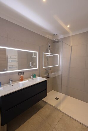 A modern bathroom with a glass-enclosed shower, a vanity with a mirror, and a sink. - Festive Holidays 🎄🥂 Villa Heated Pool 28°C (Pietrosella)