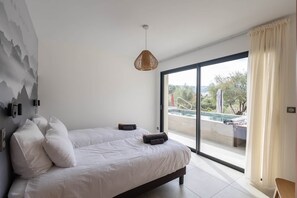 A bedroom with a large bed, a view of a swimming pool, and a mountain mural on the wall. - Festive Holidays 🎄🥂 Villa Heated Pool 28°C (Pietrosella)