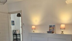 A bedroom with a large bed, two bedside lamps, and a headboard. - 70m2 house with large terrace in secure residence with swimming pool. (Bonifacio)