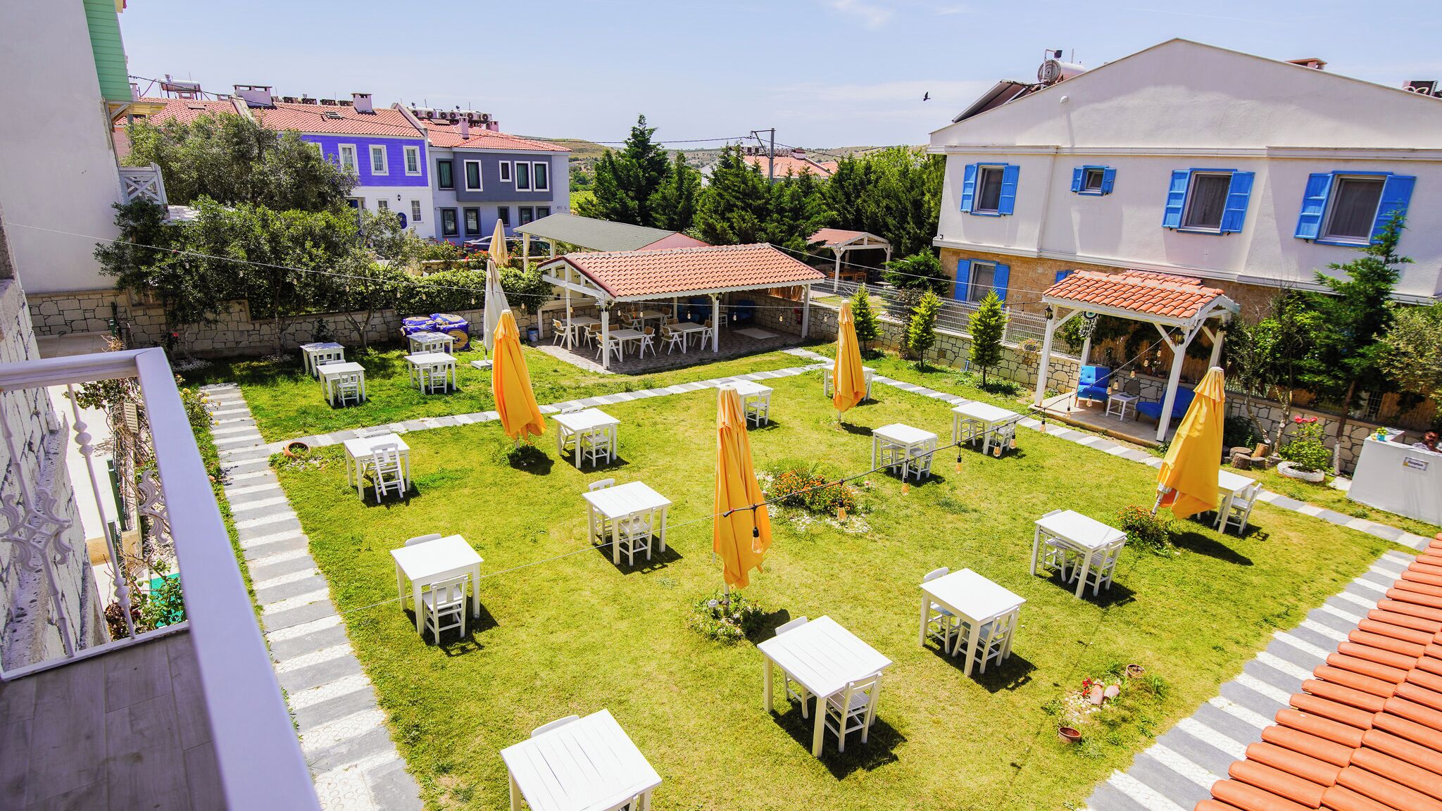 A courtyard with outdoor seating, surrounded by buildings with red-tiled roofs.