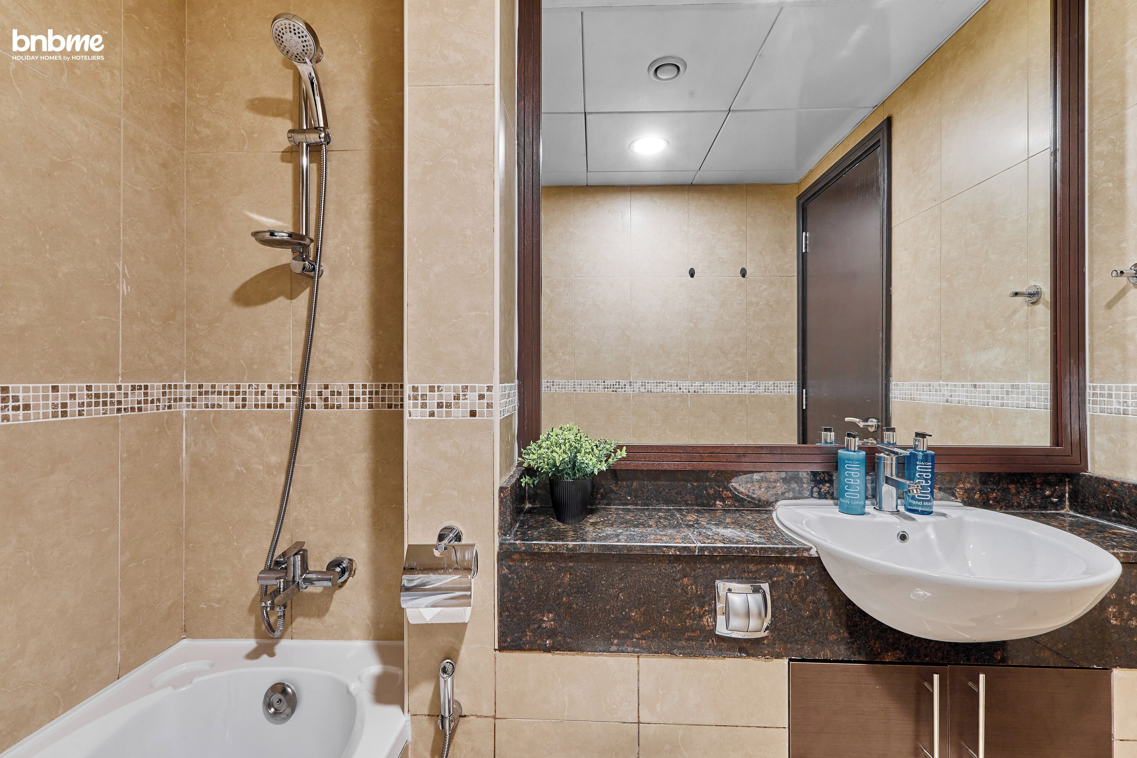 Une salle de bain avec une baignoire, une douche, un lavabo et un miroir.