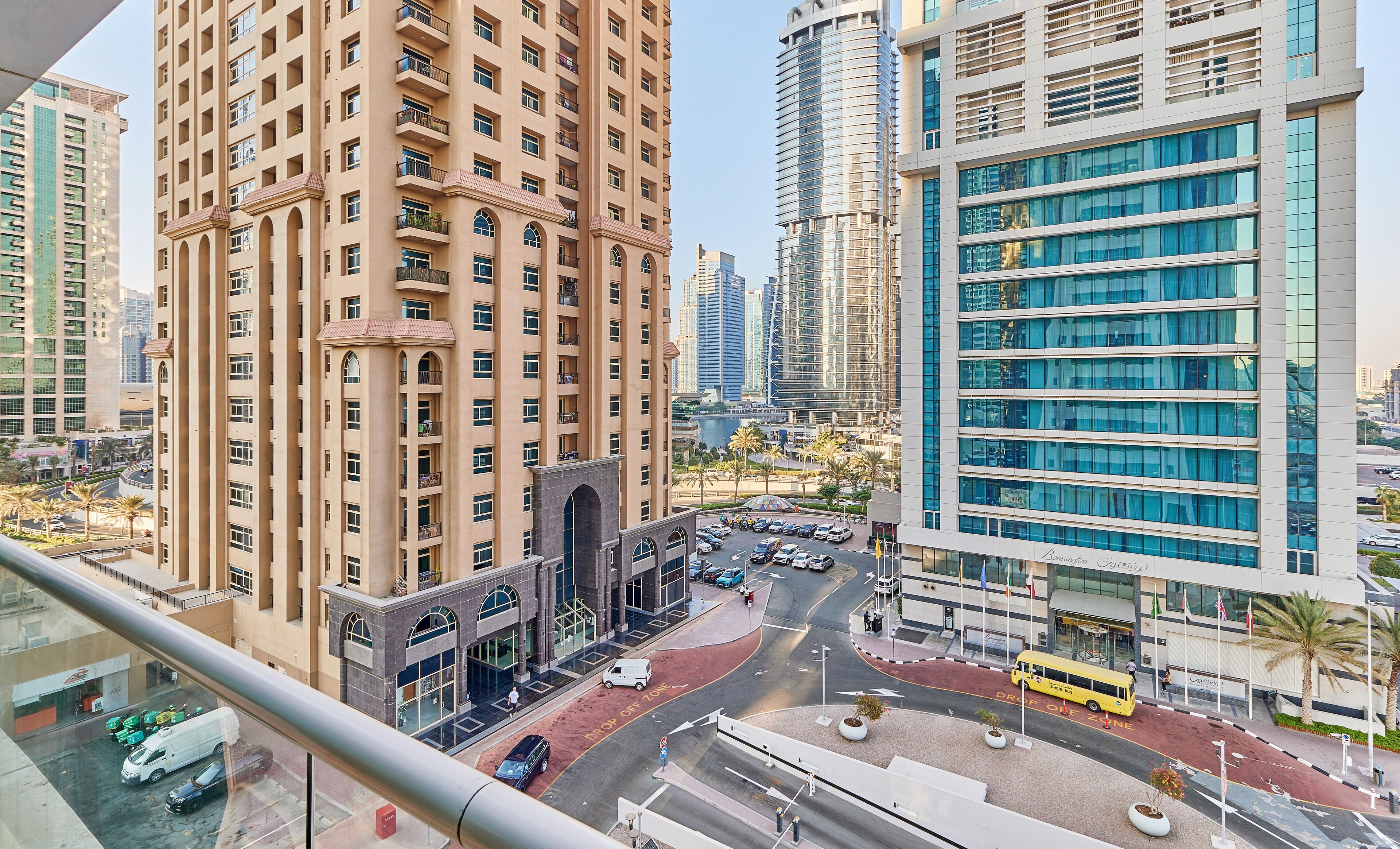 A high-rise building with a modern architectural design, featuring multiple balconies and large windows.
