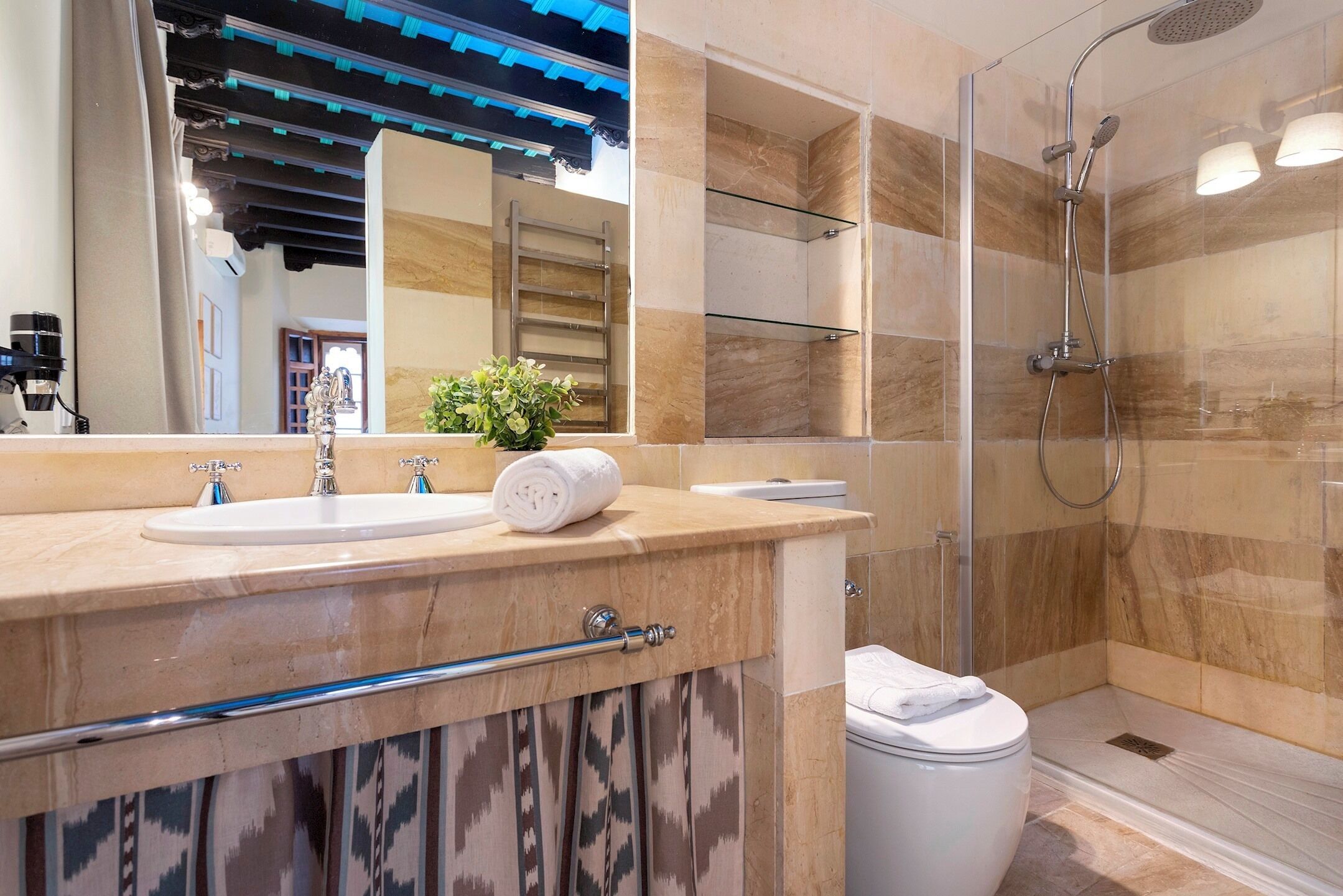 A modern bathroom with a sink, mirror, and shower.