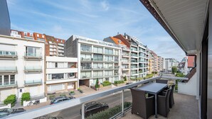 A modern apartment building with balconies, a covered outdoor seating area, and a view of the street below. - Knokke Beach Hideaway (Knokke-Heist)