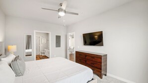 A bedroom with a bed, a dresser, a TV, and a ceiling fan. - MCK211 - Apt|Patio|15mi to Toyota Stadium|Sleeps 4 (McKinney)