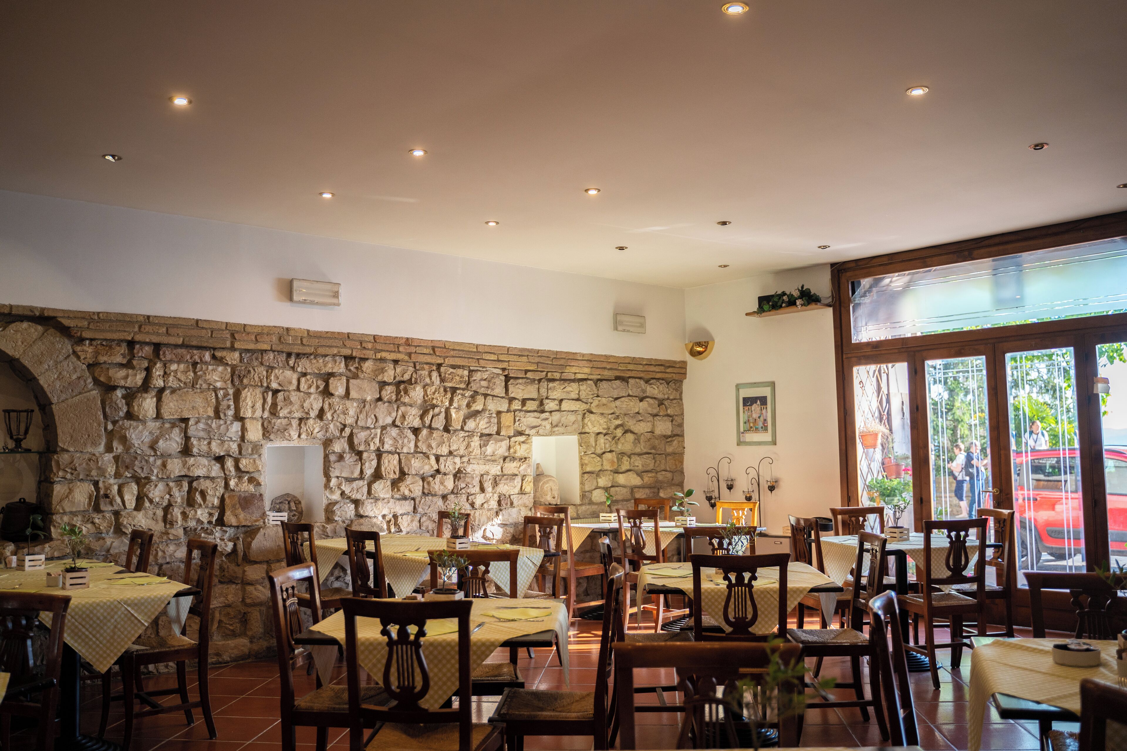 A restaurant with stone walls, wooden tables, and chairs.