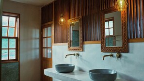 A bathroom with two sinks, wooden paneling, and a mirror with a decorative frame. - Mateves Boutique Lodge (Arusha)