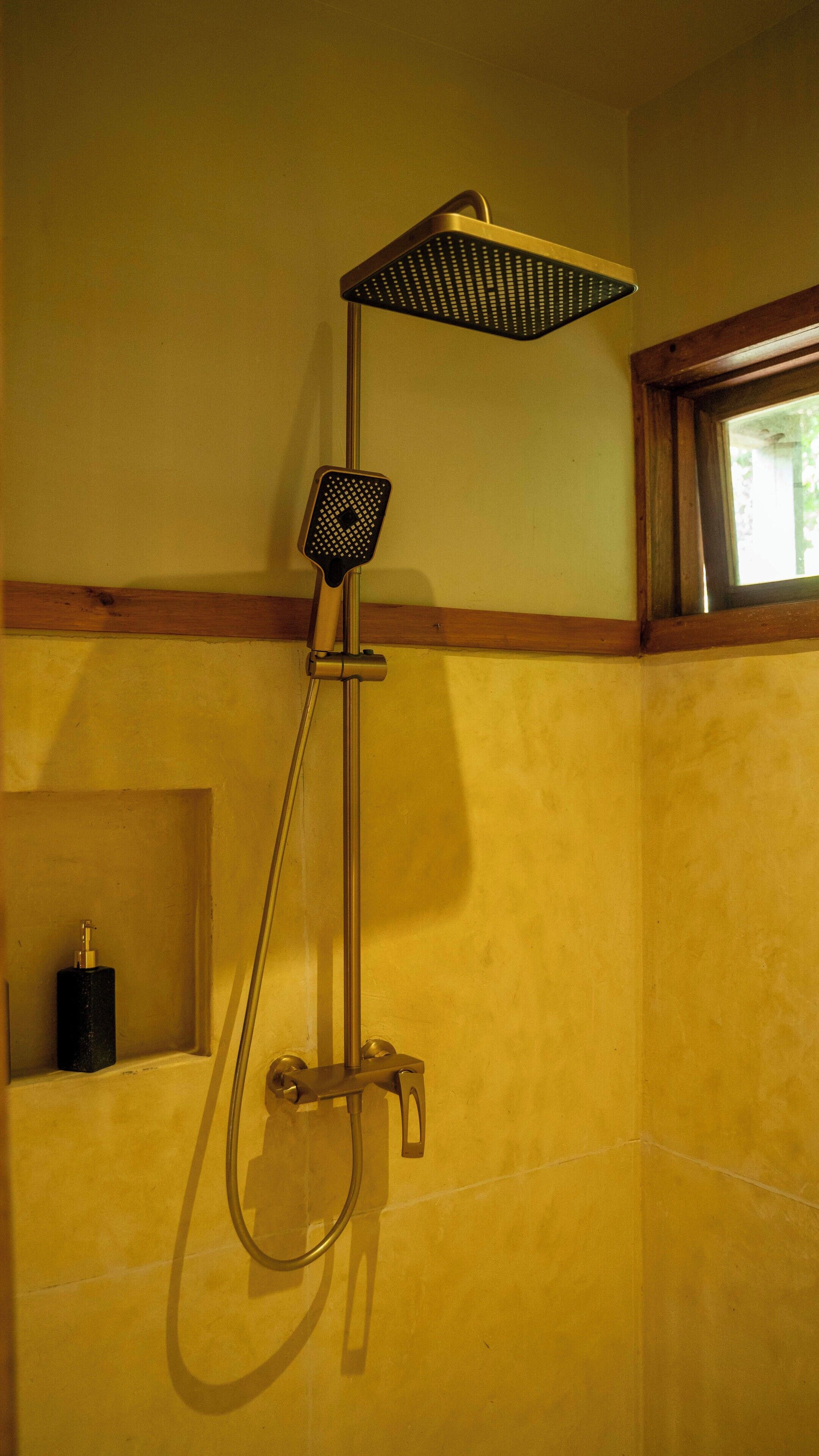 A shower with a square head and a handheld showerhead.