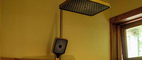 A shower with a square head and a handheld showerhead.