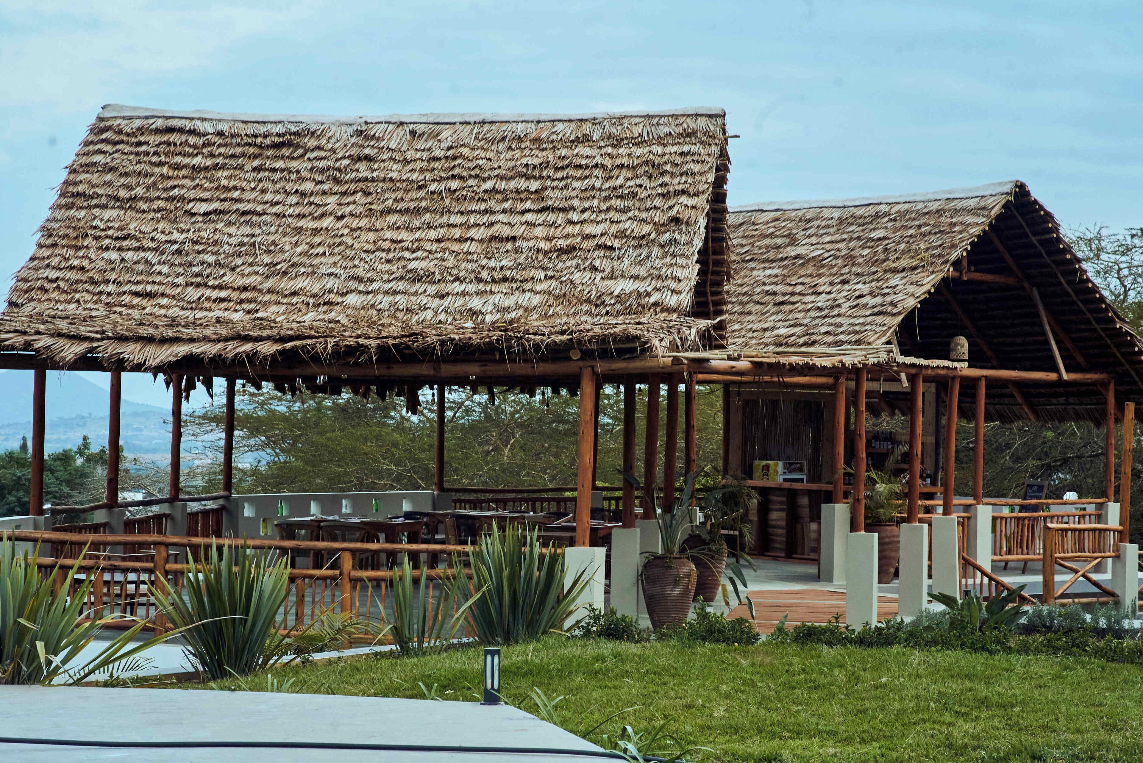 A thatched-roof structure with wooden beams and a covered seating area.