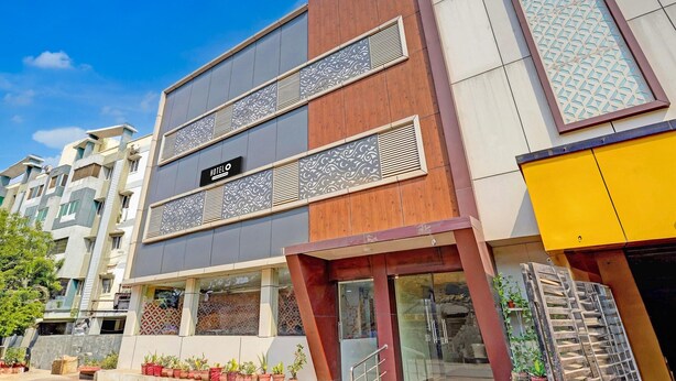 A hotel with a modern facade, featuring a mix of wood and metal panels, and a visible "HOTEL" sign. - Super Hotel O Perungalathur (Chennai)
