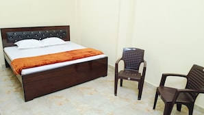 A room with a bed, two chairs, and a marble floor. - Maa Bhagwati Home Stay (Faizabad)