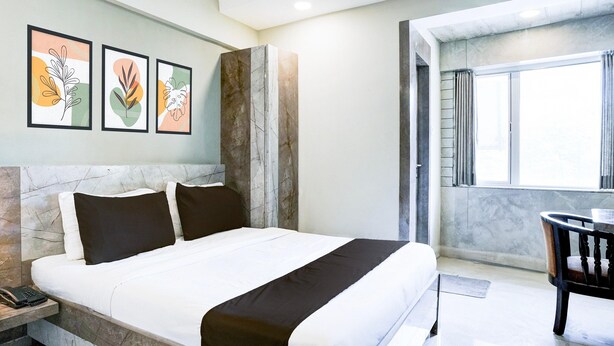 Une chambre d’hôtel avec un lit, un bureau et une fenêtre.