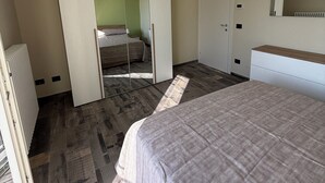 Une chambre à coucher avec un lit, une armoire, un miroir et un radiateur.