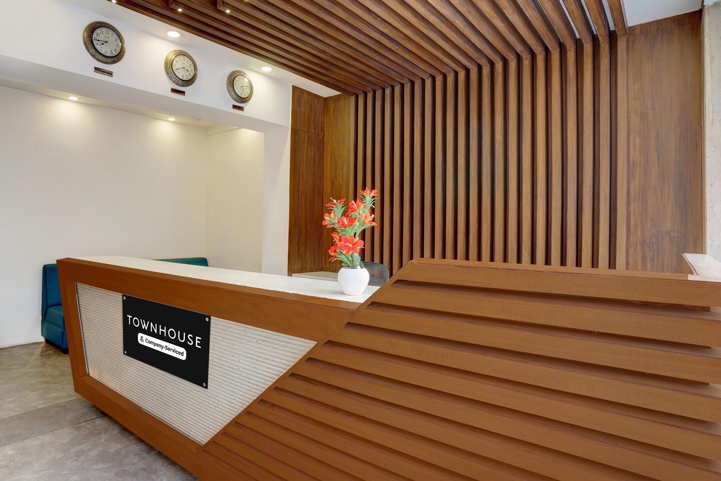 Balcão de recepção com placa indicando que é uma townhouse com serviços de empresa.