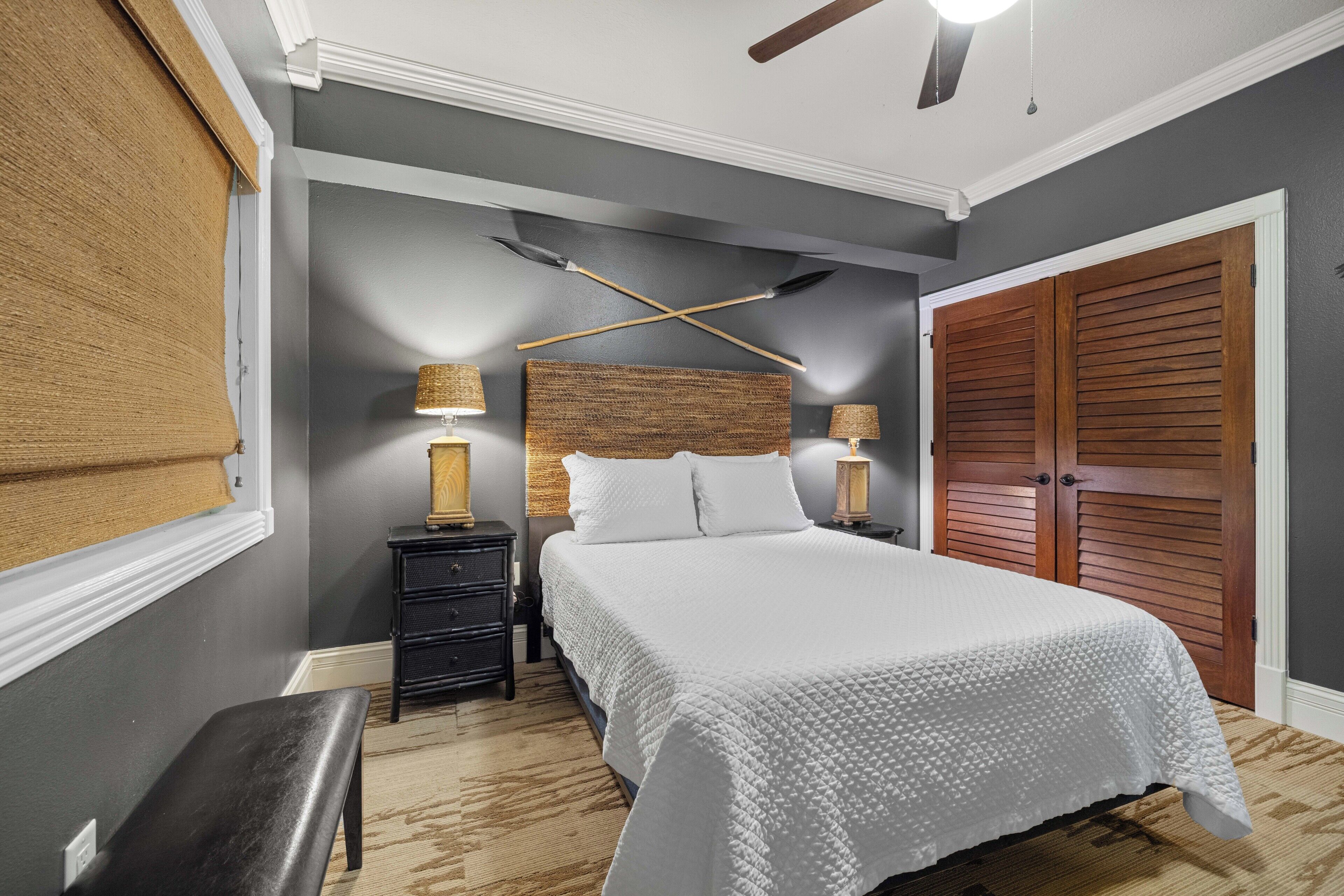 A bedroom with a bed, nightstands, a bench, and a wardrobe.