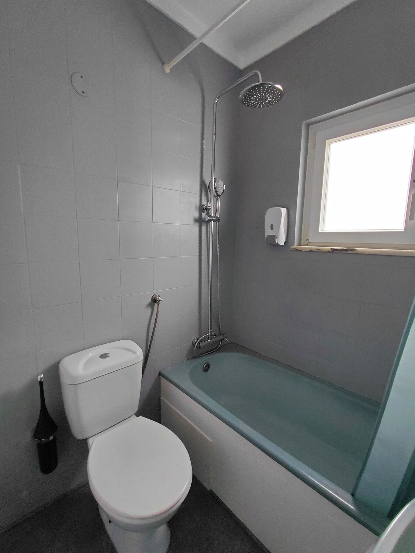 A bathroom with a toilet, a bathtub, and a shower.