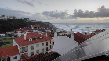 Un pueblo costero con edificios de techo rojo y vista al mar.