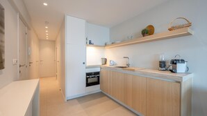 Eine moderne Küche mit Kochinsel, integriertem Backofen und Kaffeemaschine.
