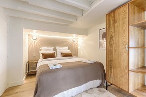 Une chambre à coucher moderne avec un grand lit, une armoire en bois et une table de chevet.