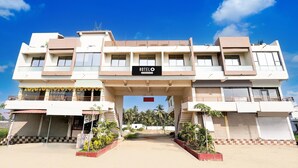 A hotel with a sign reading "HOTEL" and a clear sky. - Super Hotel O Somnath Formerly Hotel Somnath Tirth (Veraval)