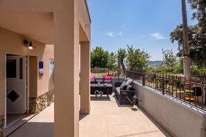 A covered outdoor seating area with a table and chairs, a heart-shaped table centerpiece, and a view of the surrounding landscape. - Harmony House Vito With Lovely Terrace (Lopar)