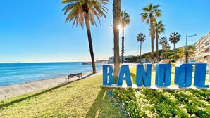 A coastal view with palm trees, a wooden boardwalk, and the word "BANDOL" in large letters. - Apartment "LA CASA SOL" ☀️ FINE SAND BEACH 1KM 🏝️⛱️🌊 (La Seyne-sur-Mer)