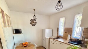 A compact kitchen with a dining table, chairs, a refrigerator, a sink, and a potted plant. - Apartment "LA CASA SOL" ☀️ FINE SAND BEACH 1KM 🏝️⛱️🌊 (La Seyne-sur-Mer)