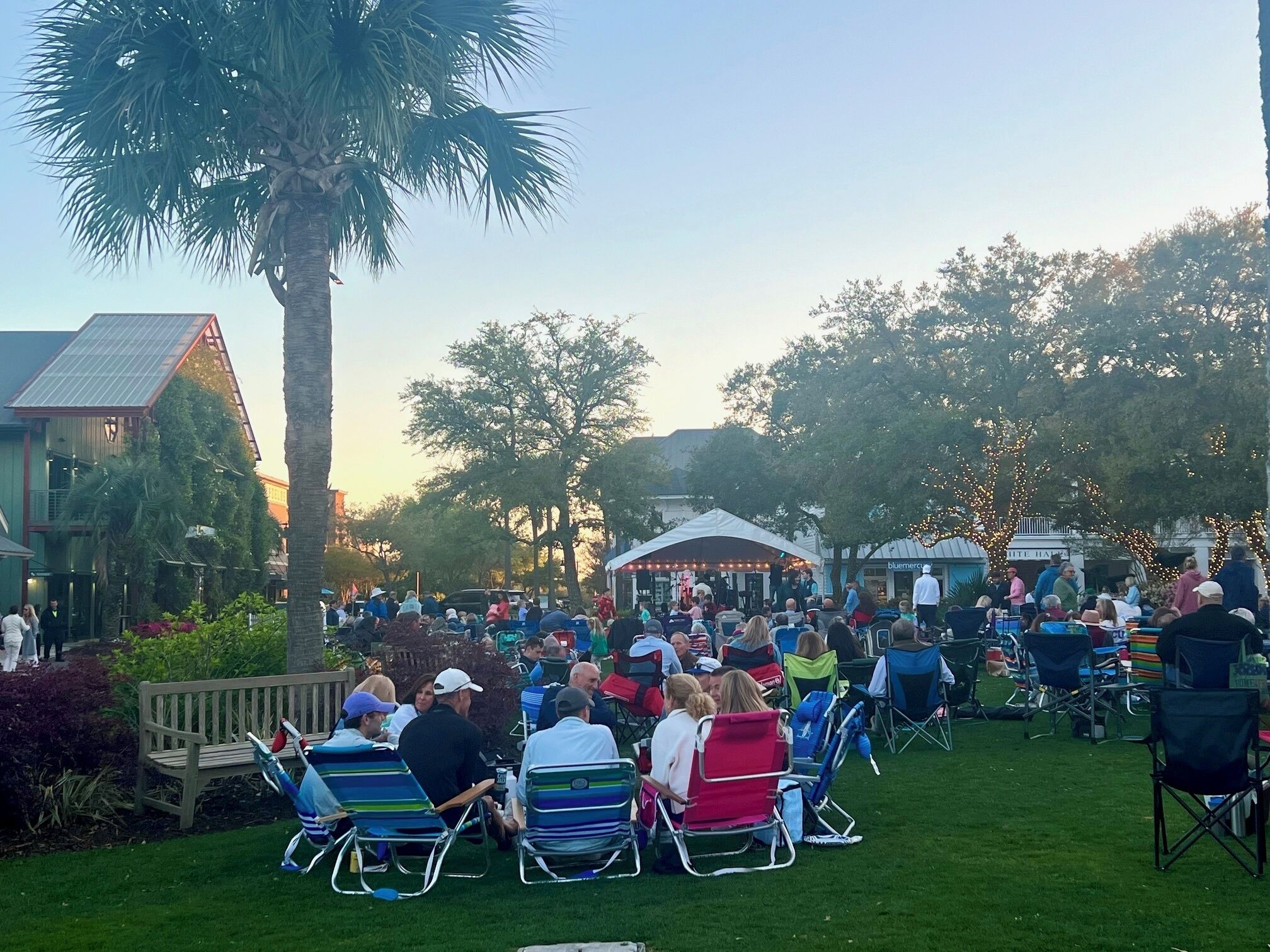An outdoor seating area with lawn chairs and a stage for an event.