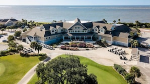 A large, multi-story building with a central courtyard, surrounded by a golf course and a body of water. - Captain's Quarters by Sandpiper | Near Beach (Seabrook Island)