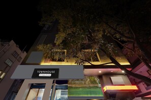Un immeuble avec une enseigne indiquant « IMMEUBLE D’HABITATION » et « Services aux entreprises ».