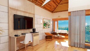 A modern living room with a flat-screen TV, wooden furniture, a coffee machine, and a large window with a scenic view. - Sunday Hotel Dharamshala (Dharamshala)