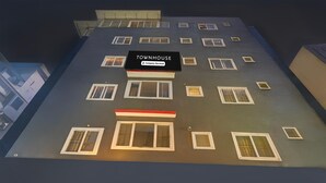 A multi-story building with a sign reading "TOWNHOUSE" and "Company Serviced." - Spacious Comfort Stays Near Aerospace Museum (Bengaluru)