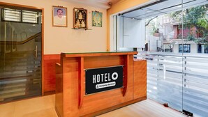 A hotel reception desk with a sign reading "HOTELO Company-Serviced".